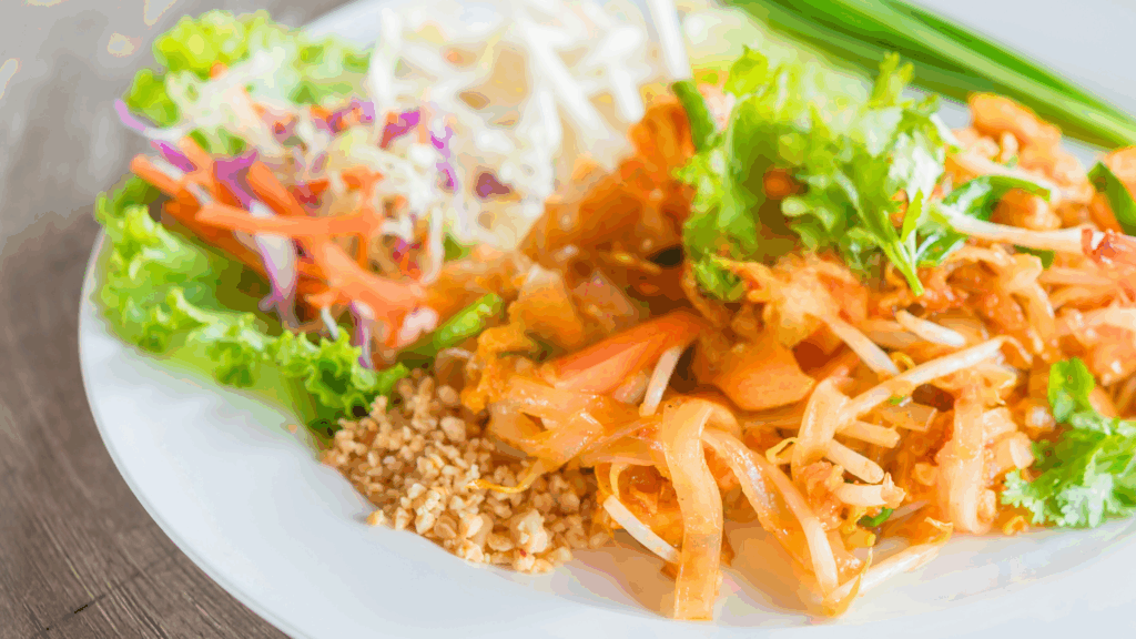 vegan Thai food on plate: curry noodles, salad