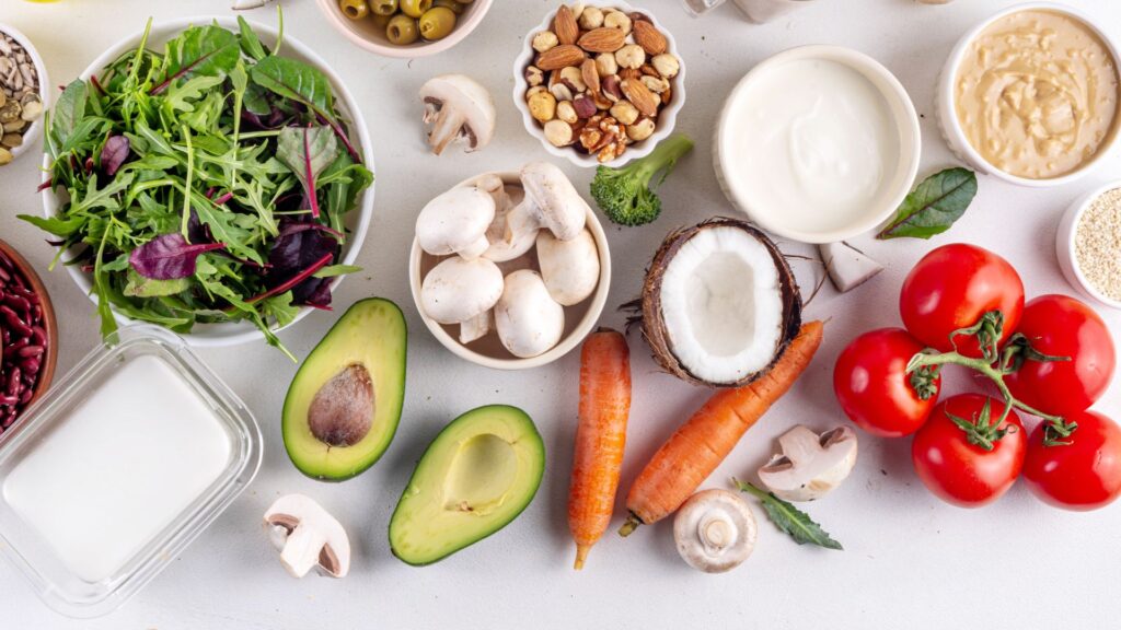 Plant foods on white background: mushroom, avocado, tomato, carrot, coconut, etc.